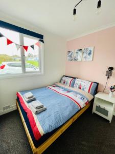 桑当“BLISS ON THE BAY ” chalet in Sandown Bay Holiday Park的一间卧室设有一张床和一个窗口