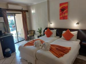 圣卢西亚St Lucia Lodge的两张位于酒店客房的床,配有毛巾