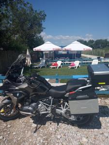 图尔恰Camping Danubius Tulcea的停在游泳池前的一辆黑色摩托车