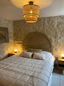 NiozellesLa Magnanerie en Provence的一间卧室配有一张大床和一个吊灯。