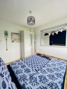 Brading“SEA HEAVEN “ chalet in Sandown Bay Holiday Park的卧室配有蓝色和白色的床。