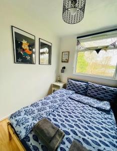 Brading“SEA HEAVEN “ chalet in Sandown Bay Holiday Park的一间卧室配有一张带蓝色棉被的床和窗户。