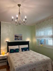 蒂瓦特Villa Mare Apartments的一间卧室配有一张带吊灯的大床