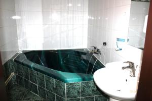 捷克捷欣中央酒店的浴室配有绿色浴缸和水槽