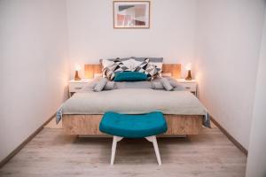Ličko Petrovo SeloGuest House Mylan的一间卧室配有一张床和一张蓝色椅子