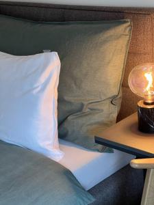 苏黎世Swiss Art Apartment City Center的一张带枕头的床和一张桌子上的台灯