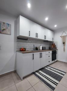 阿彻奇洛斯Stegna Rita's apartment的白色的厨房配有白色橱柜和水槽
