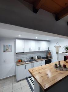 阿彻奇洛斯Stegna Rita's apartment的厨房配有白色橱柜和木桌