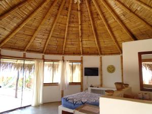 卡诺阿斯德蓬萨尔Waltako Beach Culture的卧室设有大型木制天花板和窗户。