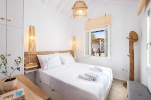 StavrosOlivea Premium Holiday Homes的白色的卧室设有床和窗户