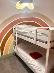 滨海绍森德3 Bedroom Spacious Seaside Apartment with Estuary Views的墙上彩虹画的双层床