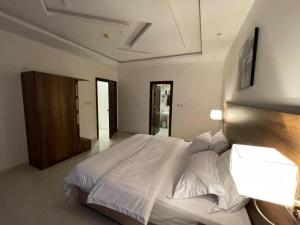 泰布克شقق سويت ستار الفندقية的卧室配有一张带两个灯的大白色床