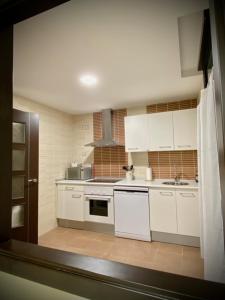 阿雷纳斯德圣佩德罗Mi Refugio的厨房配有白色橱柜和炉灶烤箱。