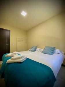 阿雷纳斯德圣佩德罗Mi Refugio的一间卧室配有两张大床和蓝色枕头