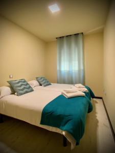 阿雷纳斯德圣佩德罗Mi Refugio的一间卧室配有一张带蓝色枕头的床和一扇窗户。