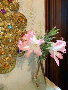 Chiquenge恩奈达乡村民宿的花瓶里满是粉红色的花朵,坐在桌子上