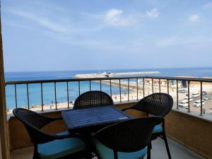 亚历山大Mermaid House的俯瞰海滩的阳台配有桌椅