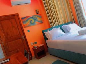 科托努HÔTEL NOAHGARDEN 2的一间小卧室,配有一张床和一扇门