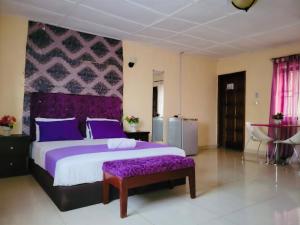 弗里敦ZUNOX GUEST HOUSE的一间卧室配有一张带紫色枕头的大床
