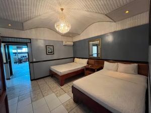 Los ChilesHotel Wilson Tulipan Los Chiles的一间卧室配有两张床和吊灯。