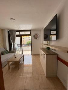 圣巴托洛梅Apartment Modern 2 Playa del Ingles的厨房以及带沙发和桌子的客厅。