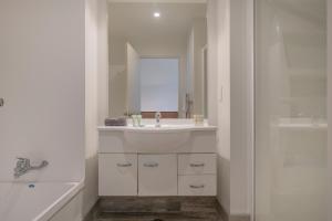 怀蒂昂格Ocean Serenity Apartments Whitianga的白色的浴室设有水槽和淋浴。