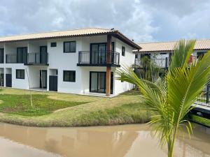 马塔迪圣若昂Apartamento Praia do Forte的前面有一条河的房子