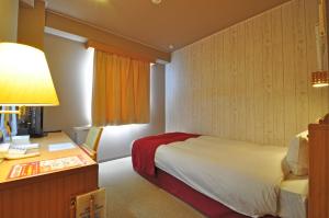 Kurihara安倍附楼酒店的配有一张床和一张书桌的酒店客房