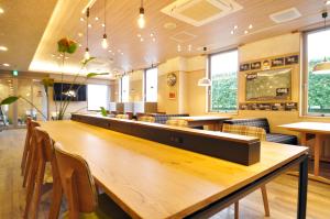 Kurihara安倍附楼酒店的餐厅设有一张大型木桌和椅子