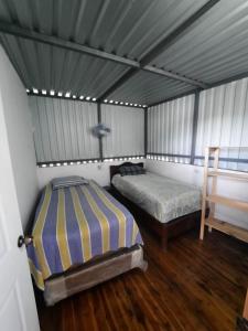 Santa ElenaHotel Colibrí Petén的一间帐篷内带两张床的卧室