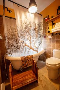 Saint-Laurent-de-l'ile d'OrleansBed and Breakfast Panorama的带浴缸和树形淋浴帘的浴室