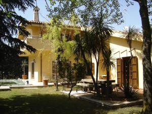拉古萨罗洛花园住宿加早餐旅馆的院子里的黄色房子,带野餐桌