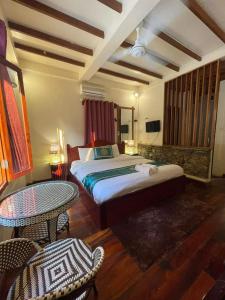 琅勃拉邦Chaluenxay Xiengthong Place的卧室配有一张床和一张桌子及椅子