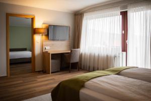 乌斯拉尔浪漫之旅酒店的酒店客房配有一张床和一张书桌及一台电视