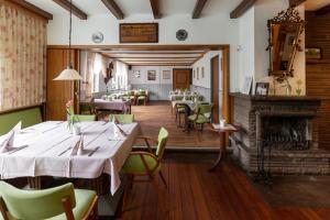 乌斯拉尔浪漫之旅酒店的一间带桌椅和壁炉的餐厅