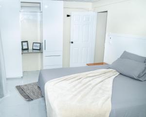 San JuanFrancis Nook Belle Garden Room的白色卧室设有床铺,铺有白色地板