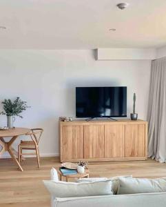 玛志洛Alby’s - Cotton Tree的客厅配有沙发和橱柜上的电视