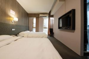 台北唯乐米窝的一间酒店客房,设有三张床和一台平面电视