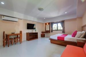 波普托Rak Samui Residence的一间卧室配有一张床、一张书桌和一台电视