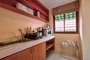波普托Rak Samui Residence的厨房配有水槽和微波炉