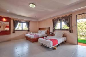 波普托Rak Samui Residence的一间卧室设有两张床、一张沙发和窗户。