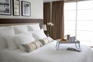 拉纳卡Sandy Beach Hotel & Spa - ex Sentido的卧室配有一张白色的床和一张桌子