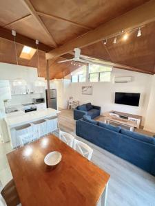 UranganMarlin Villa - Hervey Bay的客厅配有桌子和蓝色沙发