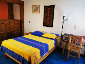 瓦哈卡市Casa Donaji的卧室配有1张床、1张桌子和1把椅子