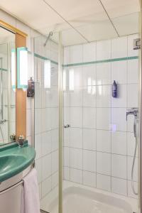 楚格巴尔楚格宜必思酒店的一间带玻璃淋浴和水槽的浴室