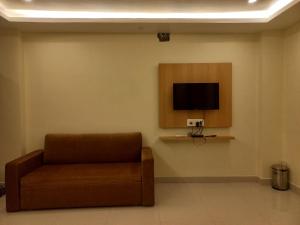 迪卡Hotel Ridley International的一间配有沙发和墙上电视的等候室