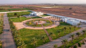 Al GhabbīJawharat Bidiyah Resort "JBR"的棕榈树建筑的空中景观