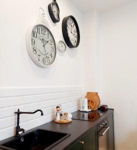 什切青Apartament w kamienicy w sercu miasta Szczecin Wały Chrobrego的厨房配有墙上的时钟和水槽