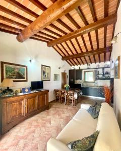 波马兰切Agriturismo Rosa dei Venti的一间带白色沙发的客厅和一间厨房