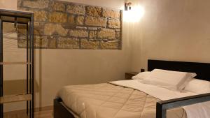蒙雷亚莱Palazzo Liberty的一间卧室设有一张床和砖墙